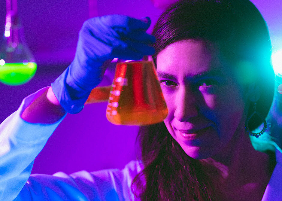 Cristina Zavaleta holding a flask of colored dye. 